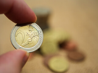 Close-Up of Two Euro Coin Held Between Fingers