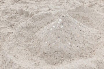 Children's entertainment sand white castle with seashells on the beach object