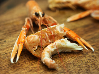 Delicious Fresh Cooked Langoustine and Peeled Piece on Wooden Table