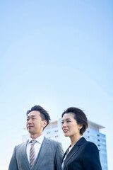 スーツ姿の男女と現代的な建築