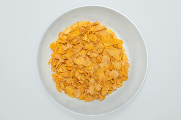 Corn flakes cereal on ceramic bowl with white background