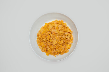 Corn flakes cereal on ceramic bowl with white background