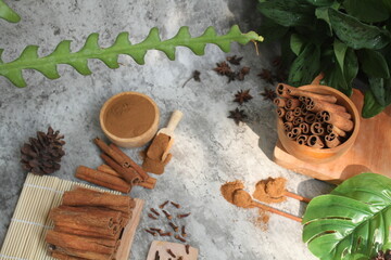 Wooden bowl with cinnamon sticks and anise on table