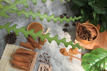 Wooden bowl with cinnamon sticks and anise on table