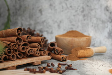 Wooden bowl with cinnamon sticks and anise on table