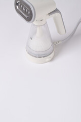 Hand steamer for clothes isolated on a white background. Portable home and travel garment steamer for clothes