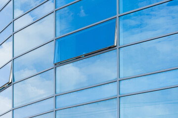 Blue glass reflects cloudy sky modern building facade exterior office texture background