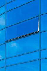 Blue glass reflects cloudy sky modern building facade exterior office texture background pattern abstract structure