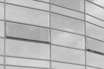Light grey glass reflects cloudy sky modern building facade exterior office texture background