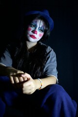 seated clown, dark portrait