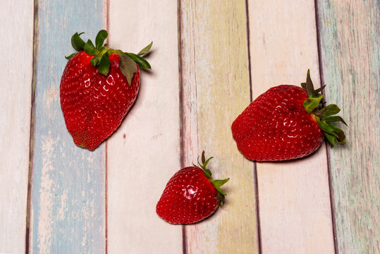 Three seasonal red strawberries.