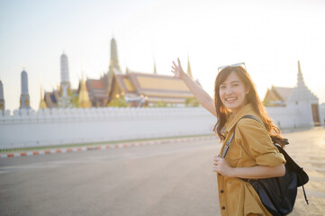 Traveler asian woman in her 30s, backpack slung over her shoulder, explores the intricate details...