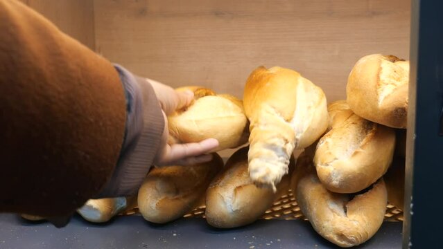 hand pick a fresh baked breads from a shelves .