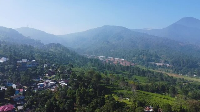Aerial view of a mountainside village in Puncak Pass on a sunny day in West Java, Indonesia