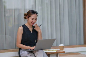 Businesswoman Planning with Laptop and Notebook