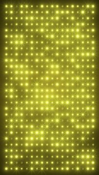 Vertical video animation of an abstract glowing yellow, orange LED wall with bright light bulbs - abstract background.