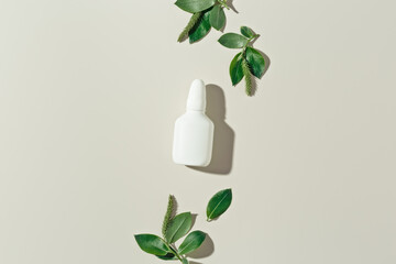 Seasonal spring allergies, fresh spring blooming branches tree with green new leaves and mock up white nasal spray bottle, beige background, top view trend pattern, Seasonal allergy concept