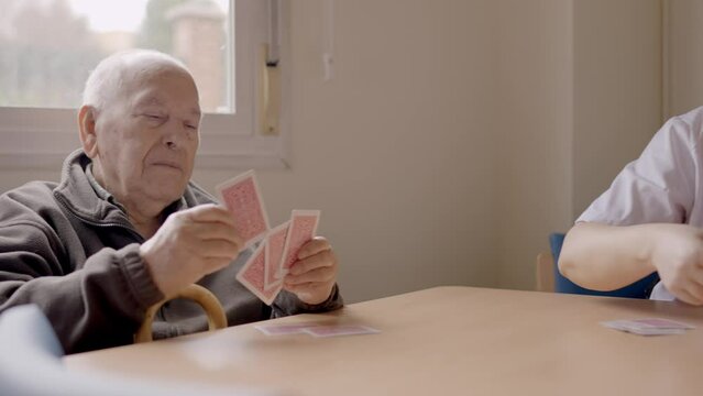 Senior man sorting cards ready to play in a geriatric