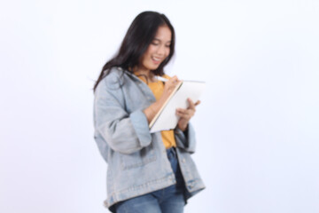 Thoughtful woman standing with paper notebook and pen, making writing to do list. Indoor studio shot isolated on white background