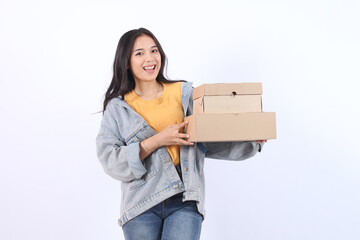 Happy Young Asian woman wearing blue jacket yellow t-shirt holding and giving package parcel boxes...