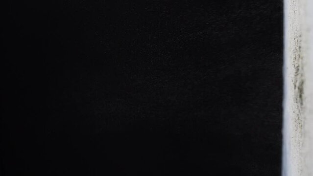 Wheat flour floating in the air against black background