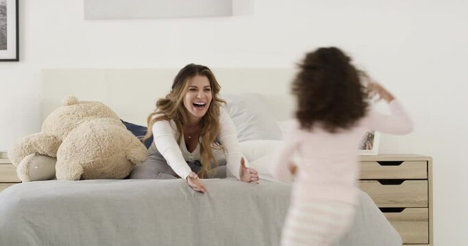 Play, hug and mom with child on bed for morning love, fun and bonding with teddy bear in home. Smile, embrace and wake up, excited mother and daughter in bedroom together with happy woman and kid.