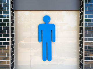 Large blue men's toilet sign on a tiled wall. Copy space background