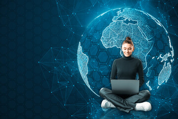 Attractive happy young european businesswoman sitting and using laptop with glowing futuristic blue...
