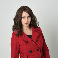 head and shoulders close up portrait of beautiful brunette woman model, wearing red trench coat...
