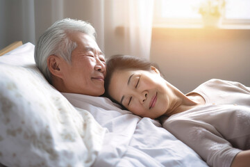 An elderly Asian man and woman in bed together, sharing affection and closeness