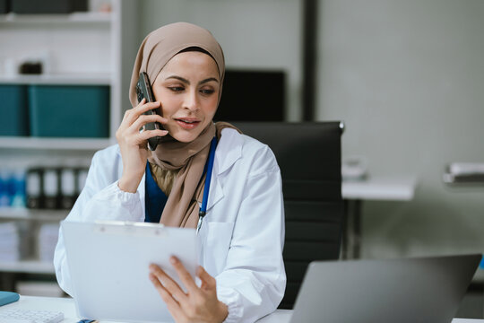 Female medicine doctor, physician or practitioner involved in cellphone call conversation giving professional consultation to patients. Medic tech concept. - Powered by Adobe
