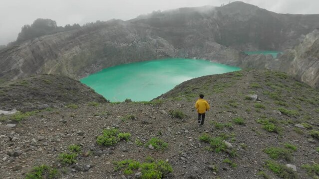 A man walks down the Kelimutu lake to see the three-colored crater