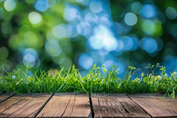 Obraz premium wooden table with green grass and blue blur background space banner display or montage your products.