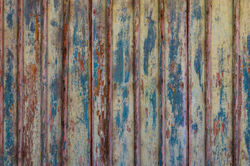 Artistic old wooden planks board texture with peeled brown and blue paint layers under sun-bleached...