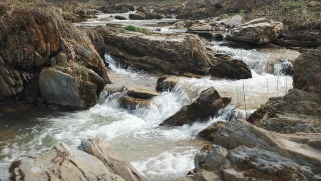 Beautiful mountain water stream or river runs down hill at calm warm spring day. Water in natural stream at national park, protected natural area or reserve. Wild nature elements concept
