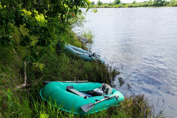 People float down a calm river in Europe in inflatable rubber boats.