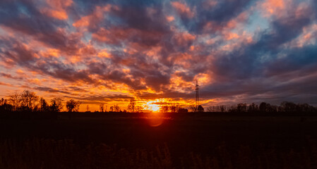 Obraz premium Sunset with a dramatic sky and overland high voltage lines near Tabertshausen, Deggendorf, Bavaria, Germany
