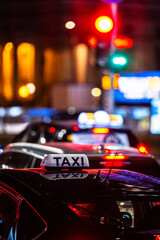 Close-up of a taxi in a traffic jam in the center of big city at night.