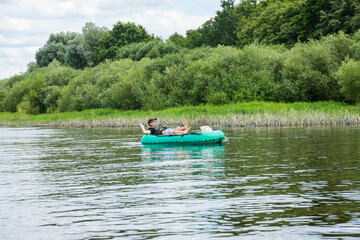 Fototapeta na wymiar people are floating on the river in an inflatable boat. The concept of outdoor activities and tourism.