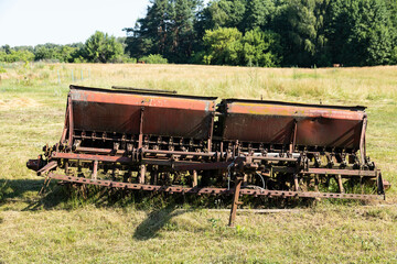 Old farm trolley seeder with gears and rusty wagon seeder.