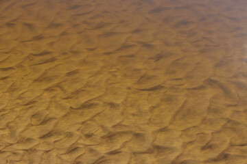 Background of river sand under water with wave sediment.
