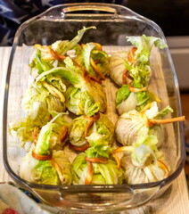 "Lazy" cabbage rolls wrapped in Peking cabbage in glass heat-resistant dishes on the background of the kitchen table