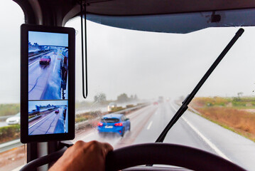 View from the driver's seat of a truck on a highway with poor visibility due to heavy rain, with the windshield wipers operating. - obrazy, fototapety, plakaty