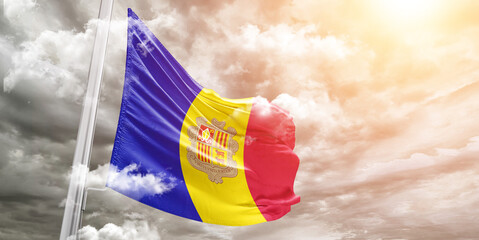 Andorra national flag cloth fabric waving on beautiful cloudy Background. - obrazy, fototapety, plakaty