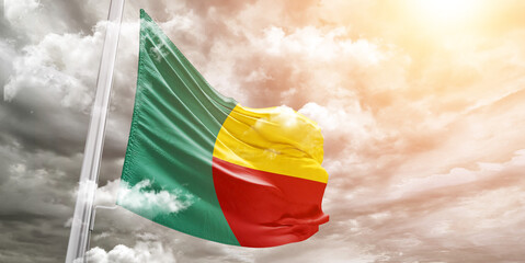 Benin national flag cloth fabric waving on beautiful cloudy Background.