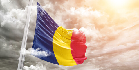 Chad national flag cloth fabric waving on beautiful cloudy Background.