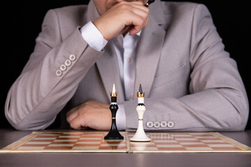 A man, a businessman sits at a chessboard. On the board is black and white king. Management...