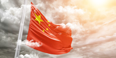 China national flag cloth fabric waving on beautiful cloudy Background.
