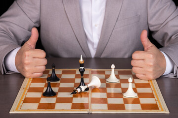 A man, a businessman plays with chess pieces, one piece beats another. The concept of power,...