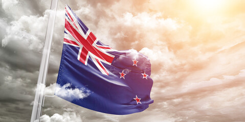 New Zealand national flag cloth fabric waving on beautiful cloudy Background.
